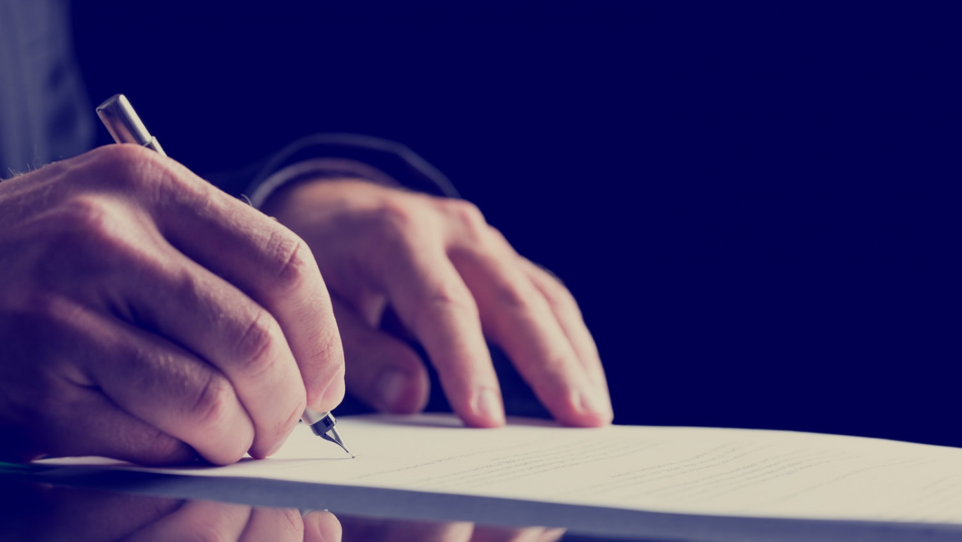 close up human hand signing on formal paper.