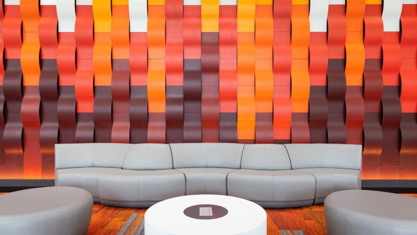 Building lobby with a vibrant abstract wall and seating.
